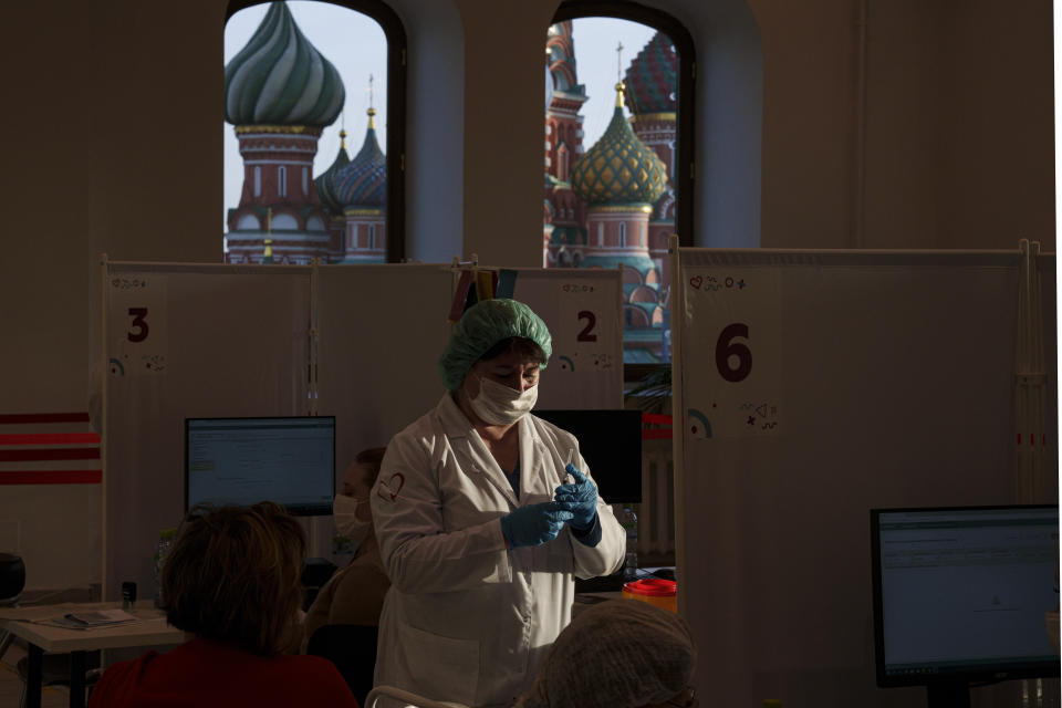 FILE - A medical worker prepares a shot of Russia's Sputnik Lite coronavirus vaccine at a vaccination center in the GUM, State Department store, in Red Square with the St. Basil Cathedral in the background, in Moscow, Russia, Oct. 26, 2021. On Monday, the U.S. will implement a new air travel policy to allow in foreign citizens who have completed a course of a vaccine approved by the Food and Drug Administration or the World Health Organization. That leaves people in Mexico, Hungary, Russia and elsewhere who received the non-approved Russian Sputnik V vaccine or the China-produced CanSino vaccine ineligible to board U.S.-bound flights. (AP Photo/Pavel Golovkin, File)