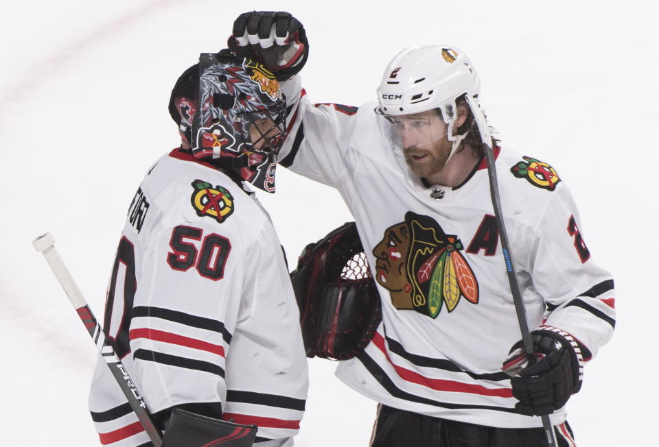 Chicago Blackhawks goaltender Corey Crawford celebrates with teammate Duncan Keith after the Blackhawks defeated the Montreal Canadiens in an NHL hockey game Wednesday, Jan. 15, 2020, in Montreal. (Graham Hughes/The Canadian Press via AP)