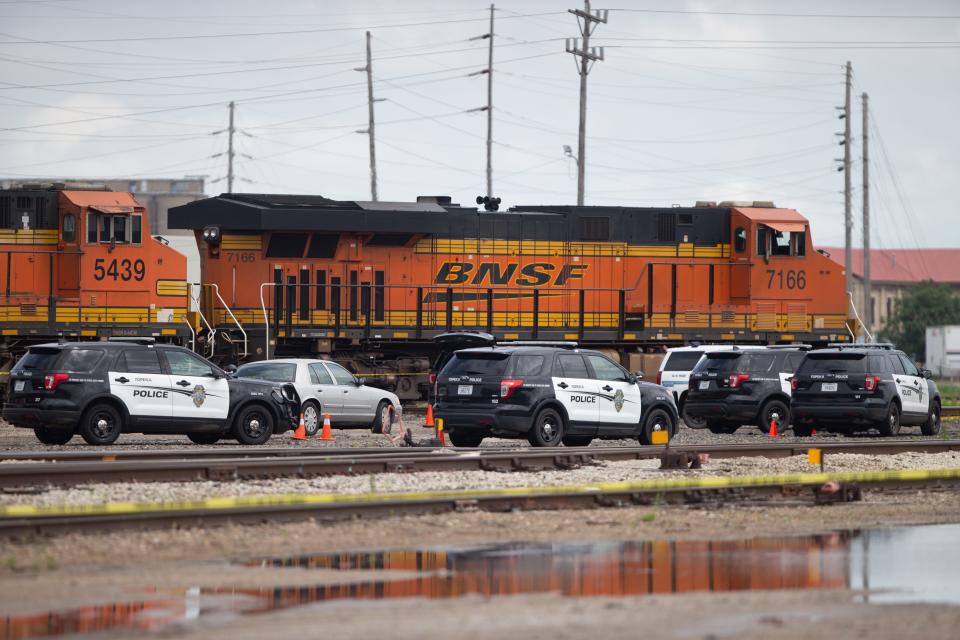Topeka police and Shawnee County sheriff's vehicles are seen parked Friday morning within a taped-off portion of railroad track after Topeka police fatally shot a man northeast of the city's Amtrak station, 500 S.E. Holliday Place.