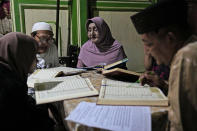 Shinta Ratri, center, founder of Al-Fatah Islamic school, reads the Quran with other trans women in Yogyakarta, Indonesia, Sunday, Nov. 6, 2022. The school whose students are transgender women is a rare oasis of LGBTQ acceptance – not only in Indonesia, but across the far-flung Muslim world. Many Muslim nations criminalize gay sex. (AP Photo/Dita Alangkara)