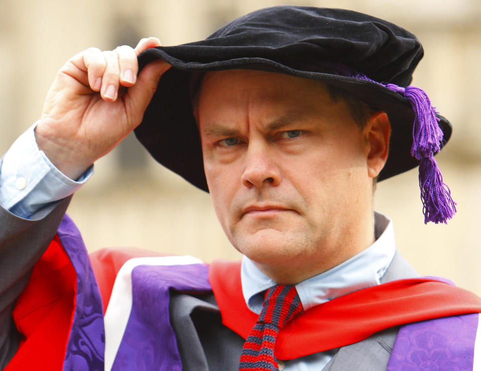 Comic Jack Dee poses in cap and gown outside Winchester Cathedral where he has been awarded an honorary degree by the city's university.