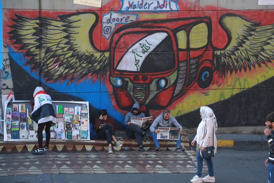 Protesters read copies of “Tuk Tuk” newspapers, in Tahrir Square, Baghdad, Iraq, Wednesday, Nov. 20, 2019. A small group of Iraqi volunteers is working in secrecy to produce the newspaper that aims to be the voice of the largest grassroots protest movement in the country’s modern history. Its editors say the newspaper is vital amid shutdowns of the internet, filling a void left by mainstream Iraqi journalists who either back the government or fear retaliation. (AP Photo/Hadi Mizban)