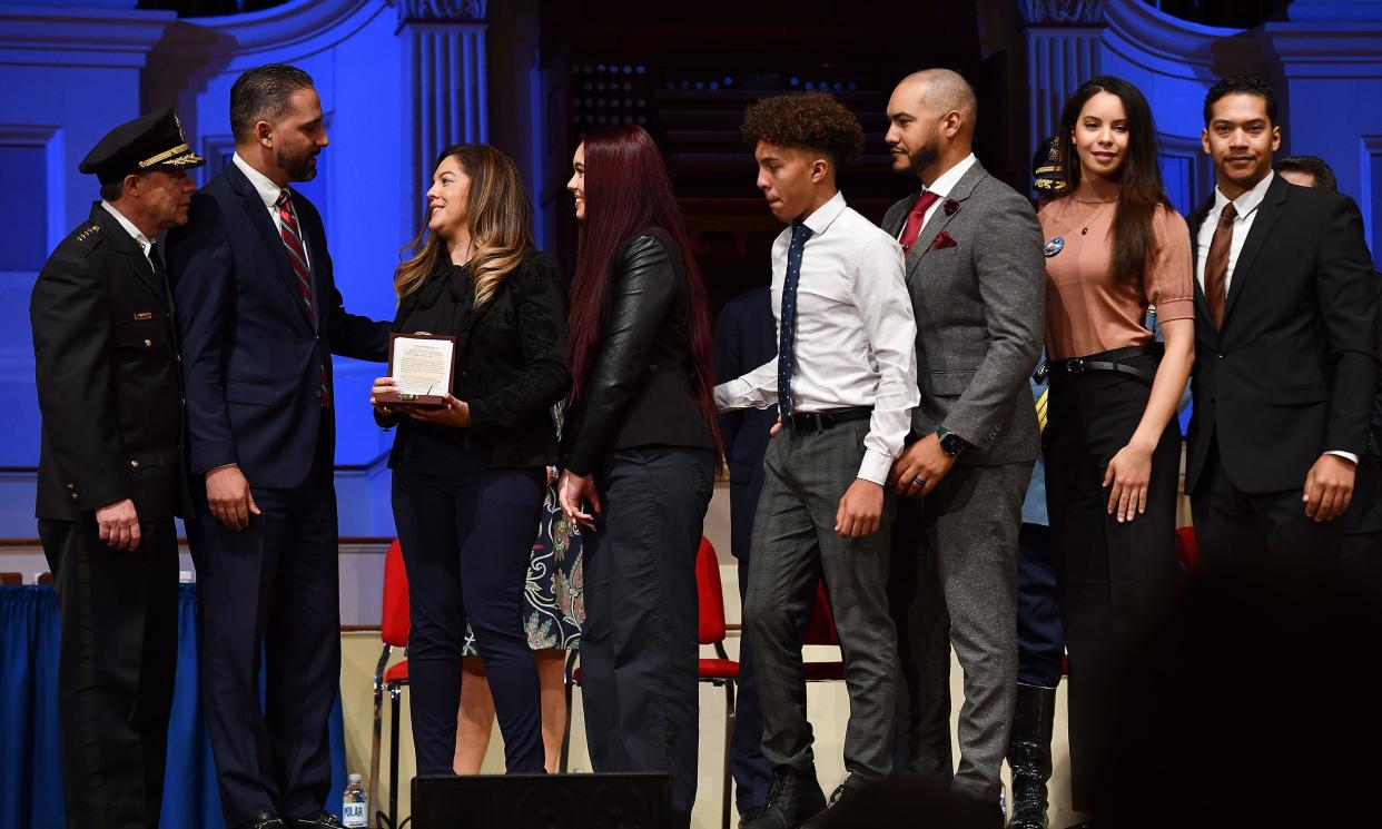 The family of fallen Worcester Police Officer Enmanuel "Manny" Familia accepts the Carnegie Award from City Manager Eric Batista during the ceremony Friday at Mechanics Hall.