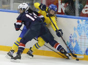 Julie Chu of the United States crashes the boards against Michelle Lowenhielm of Sweden during the third period of the 2014 Winter Olympics women's semifinal ice hockey game at Shayba Arena, Monday, Feb. 17, 2014, in Sochi, Russia. (AP Photo/Matt Slocum)