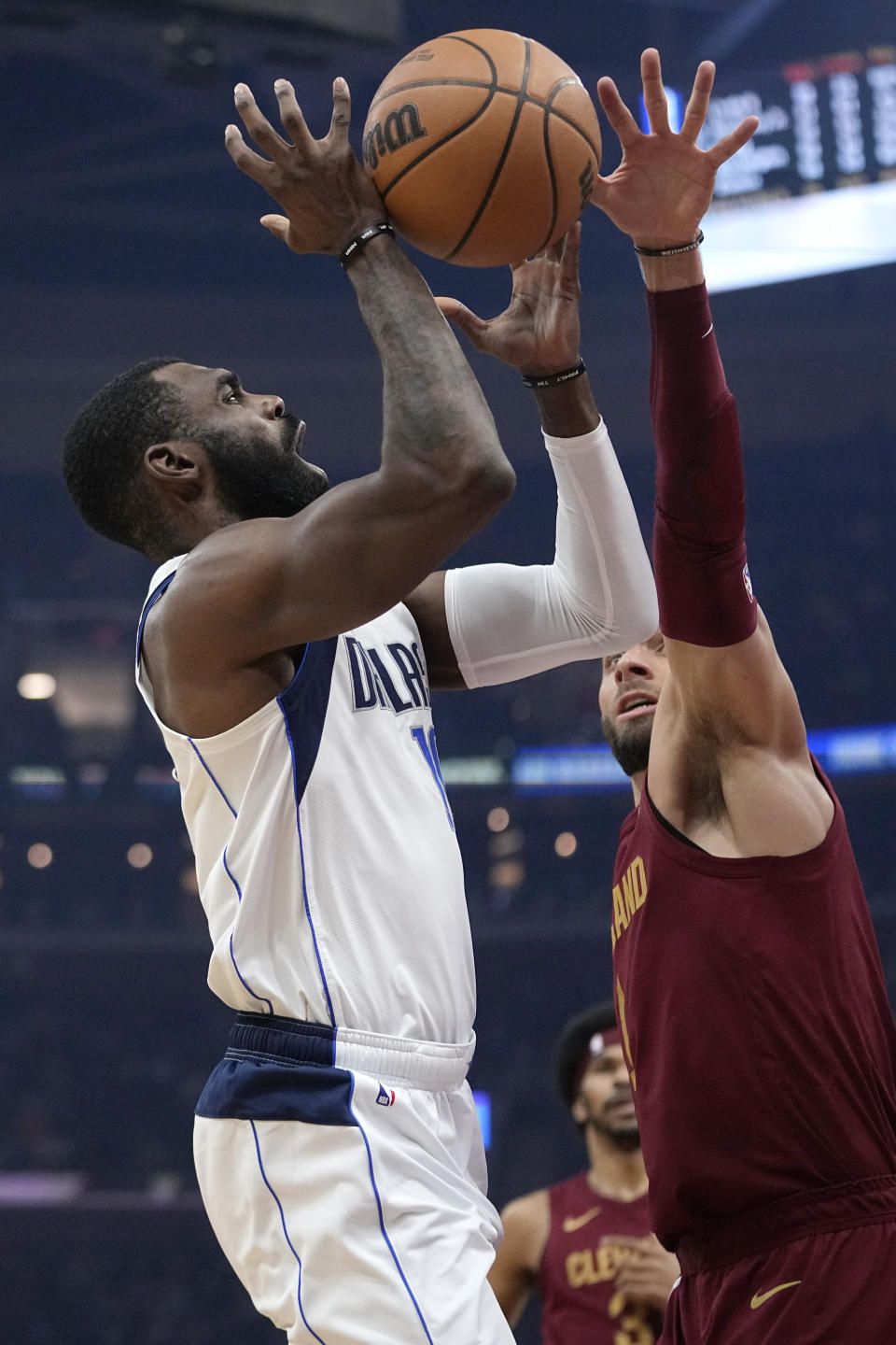 Dallas Mavericks forward Tim Hardaway Jr., left, shoots in front of Cleveland Cavaliers guard Max Strus during the first half of an NBA basketball game Tuesday, Feb. 27, 2024, in Cleveland. (AP Photo/Sue Ogrocki)