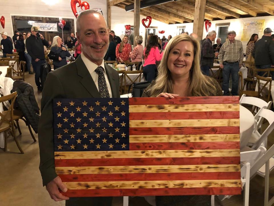 At "Light the Community" event, Virginia Delegate Kim Taylor and her husband Butch's $600 bid scored them a wooden U.S. flag crafted by Floyd Hemesath of Disputanta.