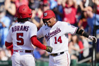 Washington Nationals' CJ Abrams (5) and Ildemaro Vargas (14) celebrate after scoring on a hit by Lane Thomas during the fifth inning of a baseball game against the Detroit Tigers at Nationals Park, Saturday, May 20, 2023, in Washington. (AP Photo/Alex Brandon)