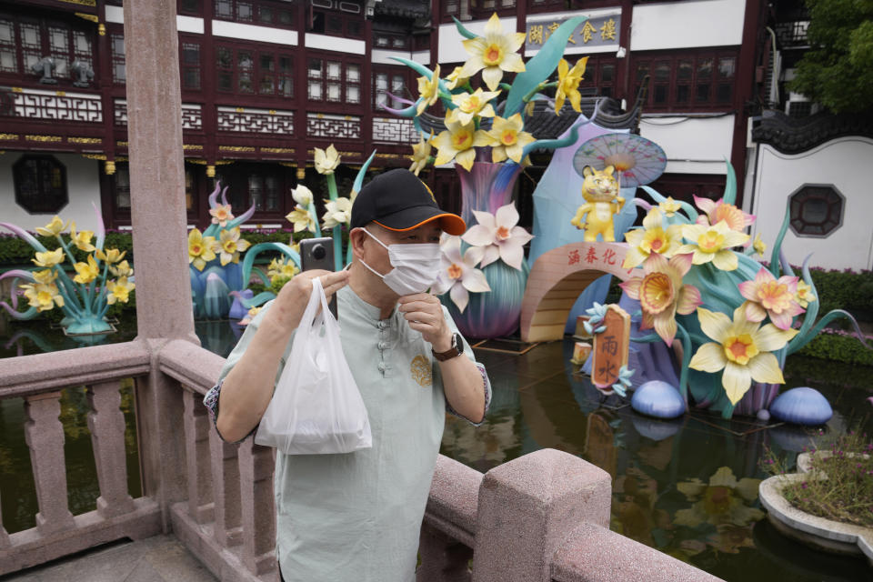 A visitor adjusts his mask during a visit to the Yu Garden Mall, Thursday, June 2, 2022, in Shanghai. Traffic, pedestrians and joggers reappeared on the streets of Shanghai on Wednesday as China's largest city began returning to normalcy amid the easing of a strict two-month COVID-19 lockdown that has drawn unusual protests over its heavy-handed implementation. (AP Photo/Ng Han Guan)