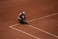 Poland's Iga Swiątek kneels on the court as she plays Maria Sakkari of Greece during their quarterfinal match of the French Open tennis tournament at the Roland Garros stadium Wednesday, June 9, 2021 in Paris. (AP Photo/Thibault Camus)