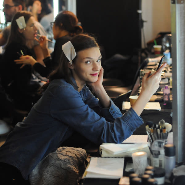 A model checks her phone backstage at Paul Smith © Getty