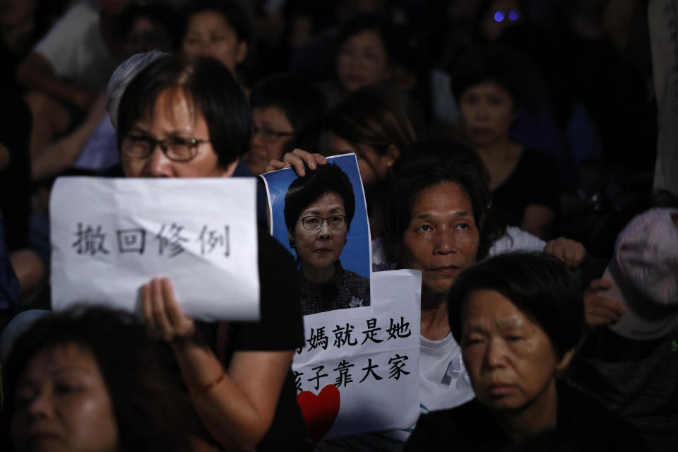 A woman holds a photo of Hong Kong Chief Executive Carrie Lam with the words "Black heart mother she is, protecting our children needs everyone" and "Withdraw extradition bill" cries as she joins a rally by mothers in support of student protesters in Hong Kong on Friday, Jan. 5, 2019. Student unions from two Hong Kong universities said Friday that they have turned down invitations from city leader Carrie Lam for talks about the recent unrest over her proposal to allow the extradition of suspects to mainland China. (AP Photo/Andy Wong)