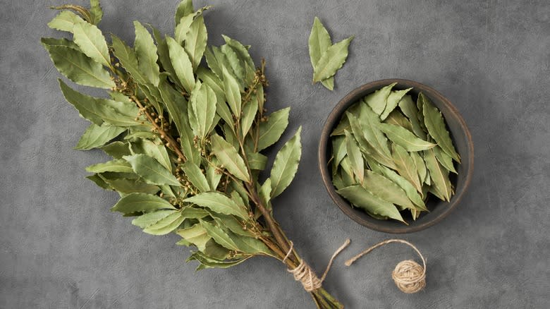 Bunch of dried bay leaves by a bowl