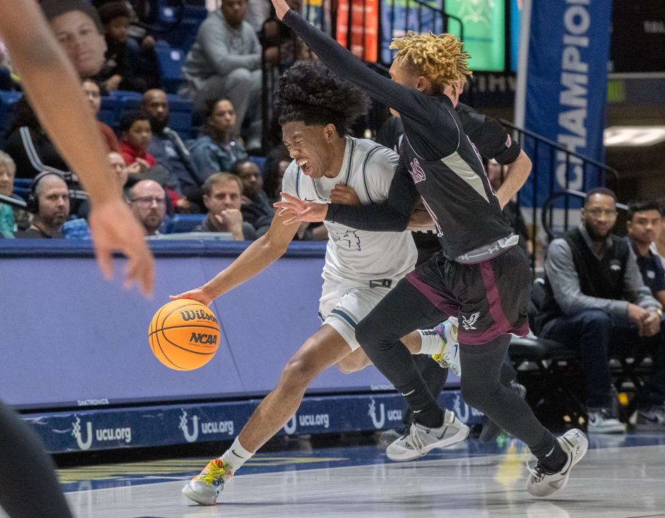 Venture Academy's DaeLeon Neal, left, drives on Natomas' Dereon Jenkins during the Sac-Joaquin Section Div. 4 boys basketball championship game at U.C. Davis' University Credit Union Center in Davis on Feb. 23, 2024. Venture Academy won 78-74.