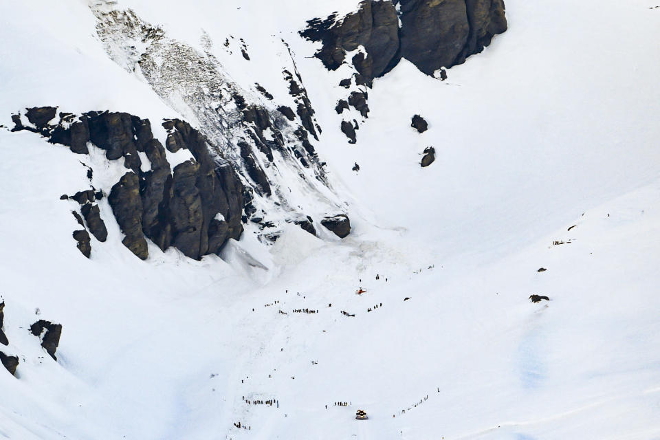 Rescue crew work on the avalanche site, at the ski resort of Crans-Montana, Switzerland, Tuesday, Feb. 19, 2019. Swiss response teams rescued at least a few people among those swept up and buried in a mid-afternoon avalanche Tuesday at the popular ski resort of Crans-Montana, police said. A frenzied search involving helicopters and rescuers “saved several people,” said spokesman Steve Leger of the Valais police, but the state of their injuries was not immediately known. (Anthony Anex/Keystone via AP)