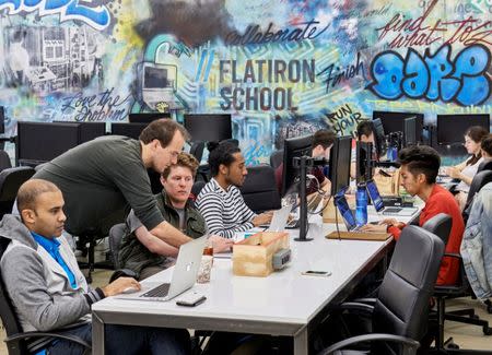 People work on computers at the Flatiron School in New York City, U.S., May 17, 2015. Courtesy of the Flatiron School/Handout via REUTERS