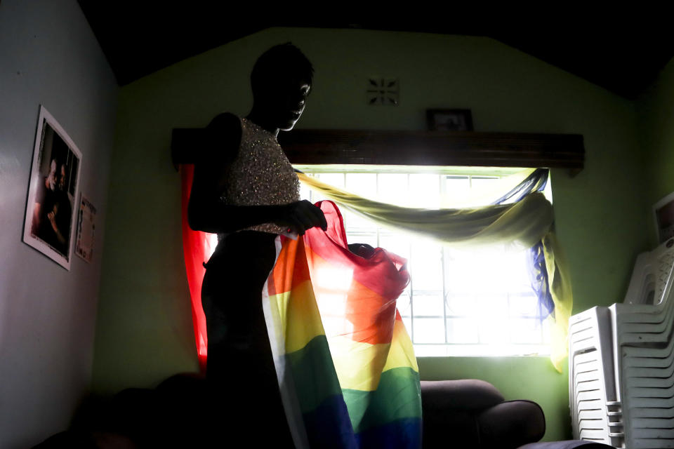 Ugandan transgender woman Pretty Peter who fled her home and country in 2019, and wished to be identified by her chosen name out of concern for her safety, holds a Pride flag at the safe house where she now lives in Nairobi, the capital of neighboring Kenya Thursday, June 1, 2023. She says frightened members of the Ugandan LGBTQ+ community are searching for a way to get out of the country and some have stayed indoors since new anti-gay legislation was signed on Monday. (AP Photo/Brian Inganga)