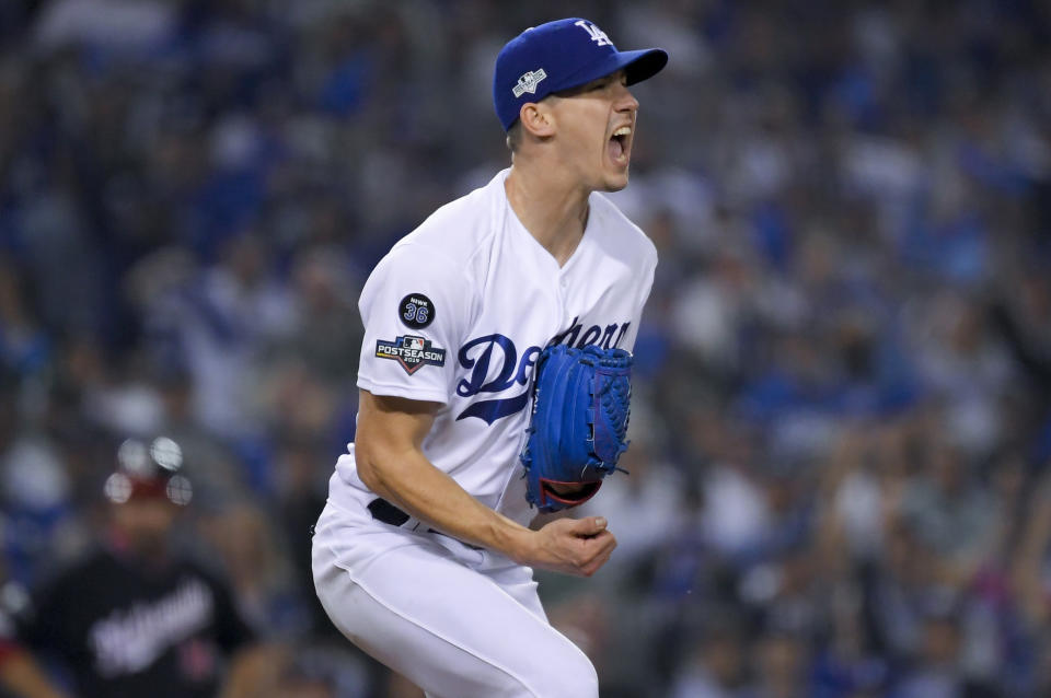 FILE - In this Oct. 9, 2019 file photo, Los Angeles Dodgers starting pitcher Walker Buehler celebrates after striking out Washington Nationals' Ryan Zimmerman to end the top of the sixth inning in Game 5 of a baseball National League Division Series in Los Angeles. In what's become a familiar refrain, the Dodgers arrive at camp still looking for their first World Series championship since 1988. After losing in two straight World Series, they were ousted by Washington in five games in the NL Division Series last fall. (AP Photo/Mark J. Terrill, File)