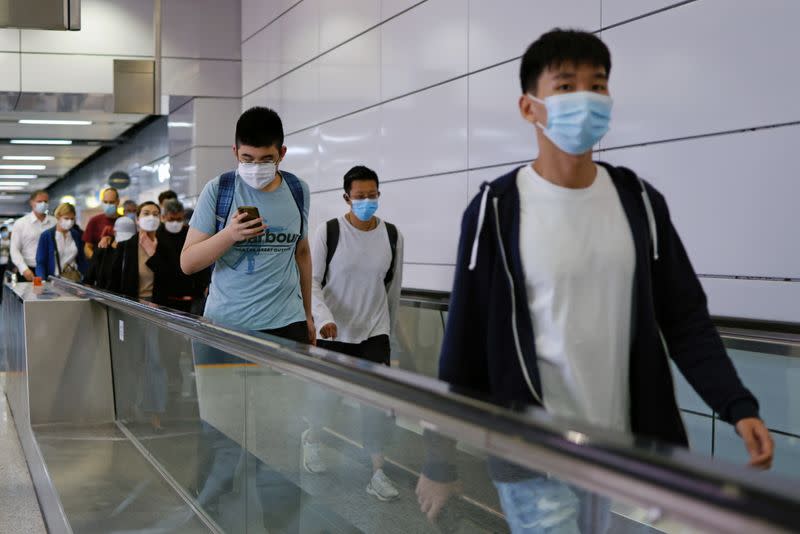 People wear masks following the coronavirus disease (COVID-19) outbreak, at the financial Central district in Hong Kong