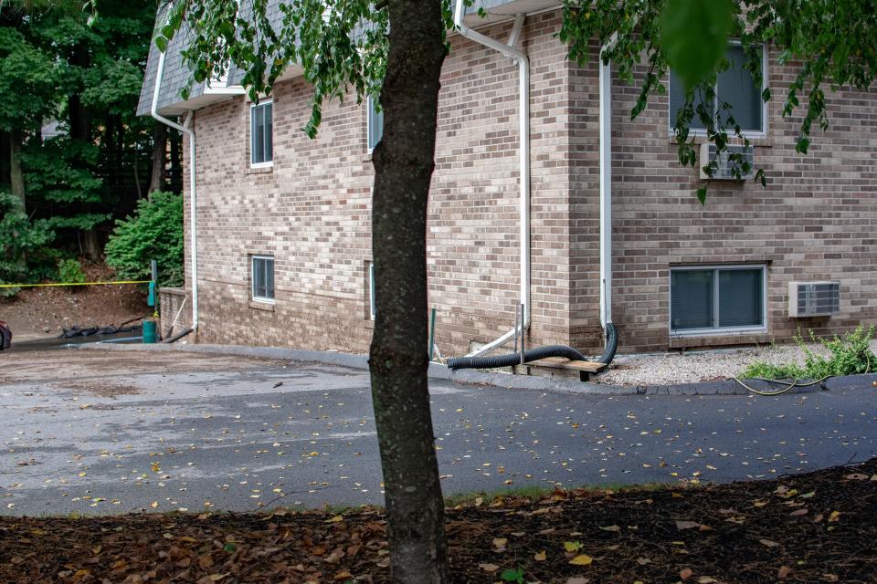 The high-water line at the Dean Estates apartments following flooding is marked by a film of mulch on the side of the building, hitting the bottom of windows on the basement units.