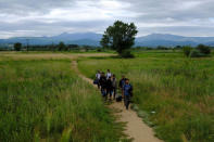 People walk through fields after they were sent out during a police operation to evacuate a makeshift camp at the Greek-Macedonian border near the village of Idomeni, Greece, May 25, 2016. REUTERS/Marko Djurica