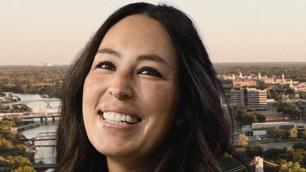 a woman smiling with a city in the background