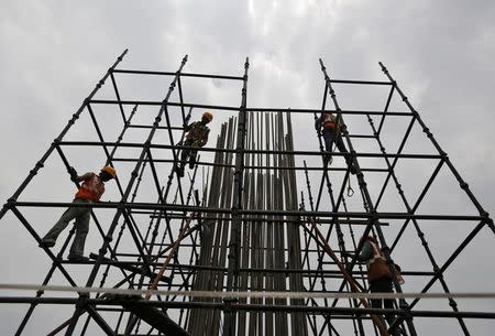 Workers erect scaffolding to build a pillar at the site of the metro railway flyover under construction in Ahmedabad, India, June 30, 2016. REUTERS/Amit Dave/Files