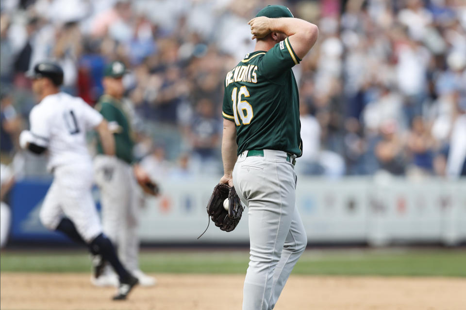 Oakland Athletics' relief pitcher Liam Hendriks (16) reacts after allowing a game-tying, solo home run to New York Yankees' Brett Gardner, left, who rounds the bases in the ninth inning of a baseball game, Sunday, Sept. 1, 2019, in New York. (AP Photo/Kathy Willens)