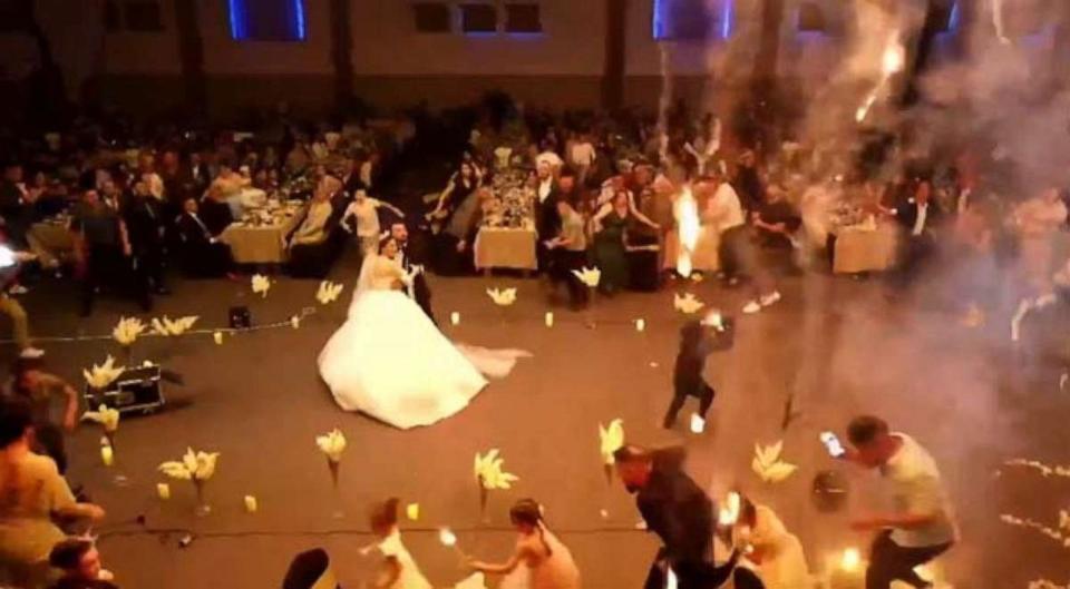 PHOTO: In a screenshot from a livestream of the wedding, wedding guests begin to flee as burning material drops from the ceiling. (Studio 4B)