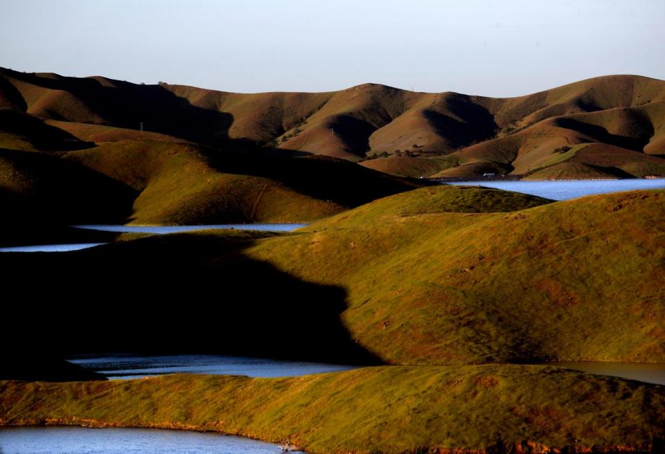 A view of bodies of water amid rolling brown hills