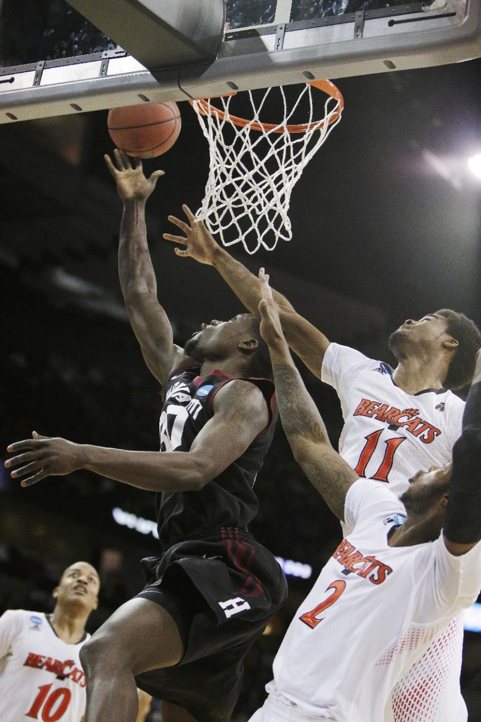Harvard’s Kyle Casey (30) attempts a layup against Cincinnati’s Jermaine Lawrence (11) and Titus Rubles (2) in the first half during the second-round game of the NCAA college basketball tournament in Spokane, Wash., Thursday, March 20, 2014. (AP Photo/Young Kwak)