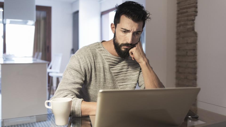 Man working at home with laptop computer.