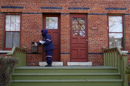 Mail carrier Marissa Ogletree delivers mail in the historic Pullman neighborhood in Chicago November 20, 2014. REUTERS/Andrew Nelles