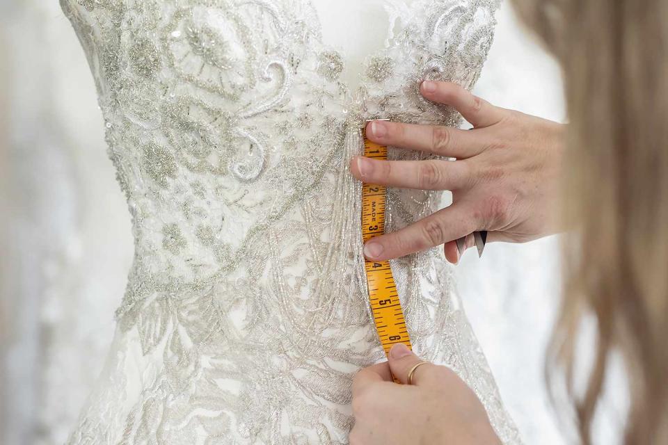 <p>Getty</p> Stock image of a tailor working on a wedding dress