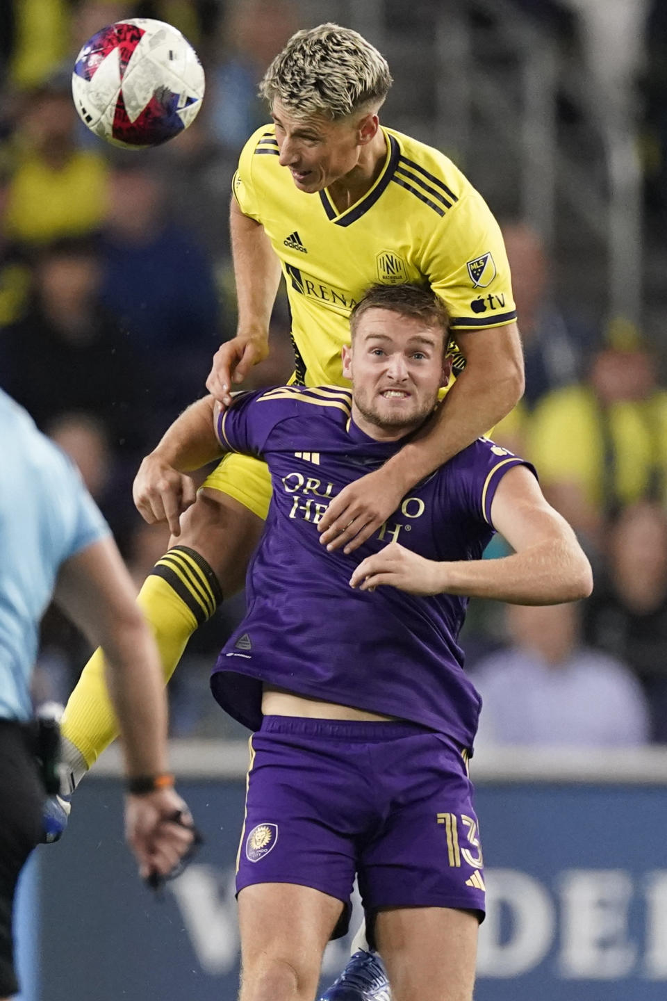 Nashville SC defender Lukas MacNaughton heads the ball over Orlando City forward Duncan McGuire (13) during the first half of an MLS playoff soccer match Tuesday, Nov. 7, 2023, in Nashville, Tenn. (AP Photo/George Walker IV)