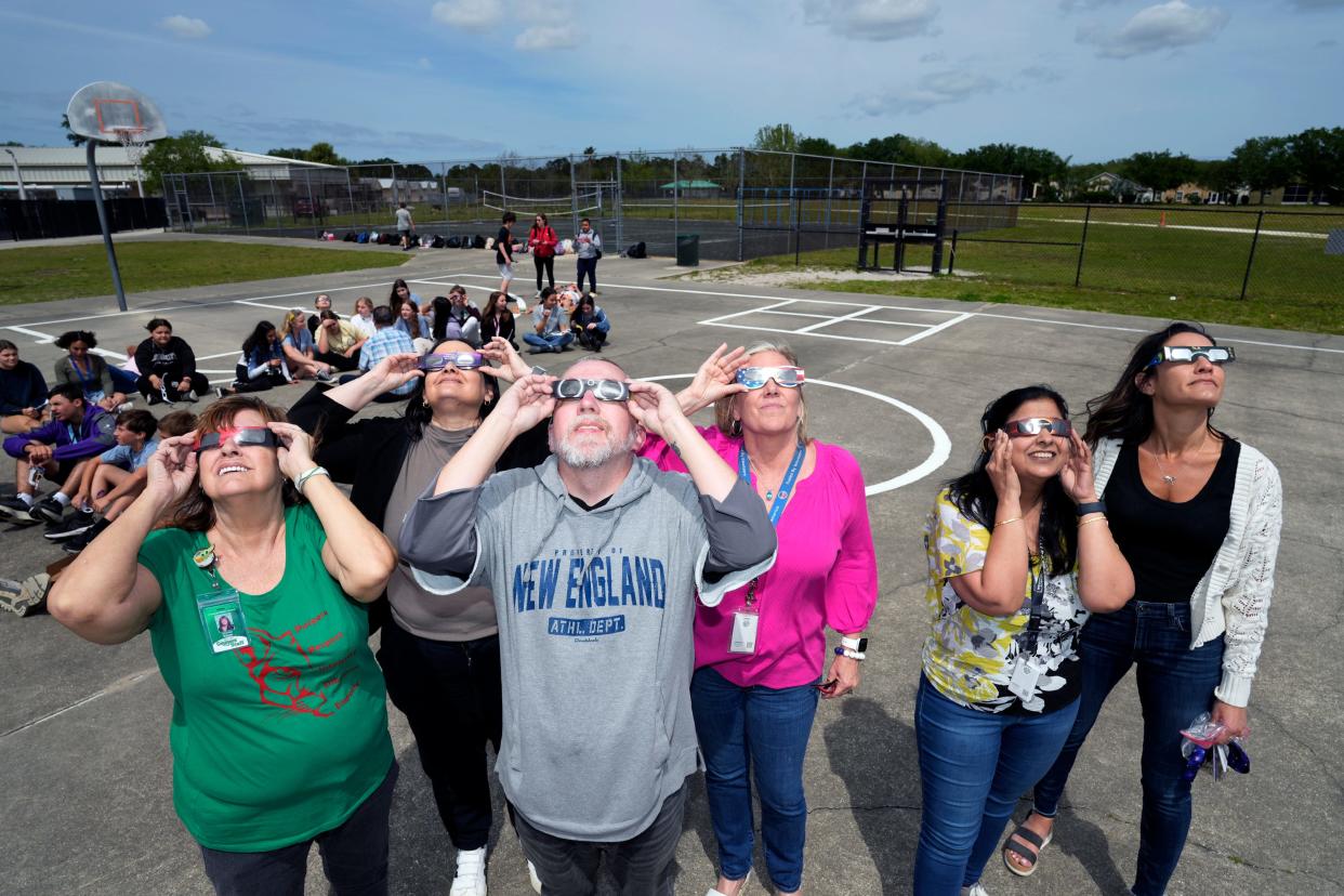 Teachers and students at Creekside Middle School in Port Orange watch Monday afternoon's solar eclipse during an in-school field trip.