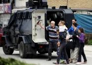 People are evacuated with an armoured vehicle near a police checkpoint in Kumanovo, Macedonia May 9, 2015. REUTERS/Ognen Teofilovski