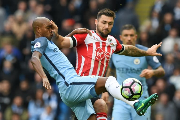 Manchester City's midfielder Fernandinho (L) vies with Southampton's striker Charlie Austin during the 1-1 draw in Manchester on October 23, 2016