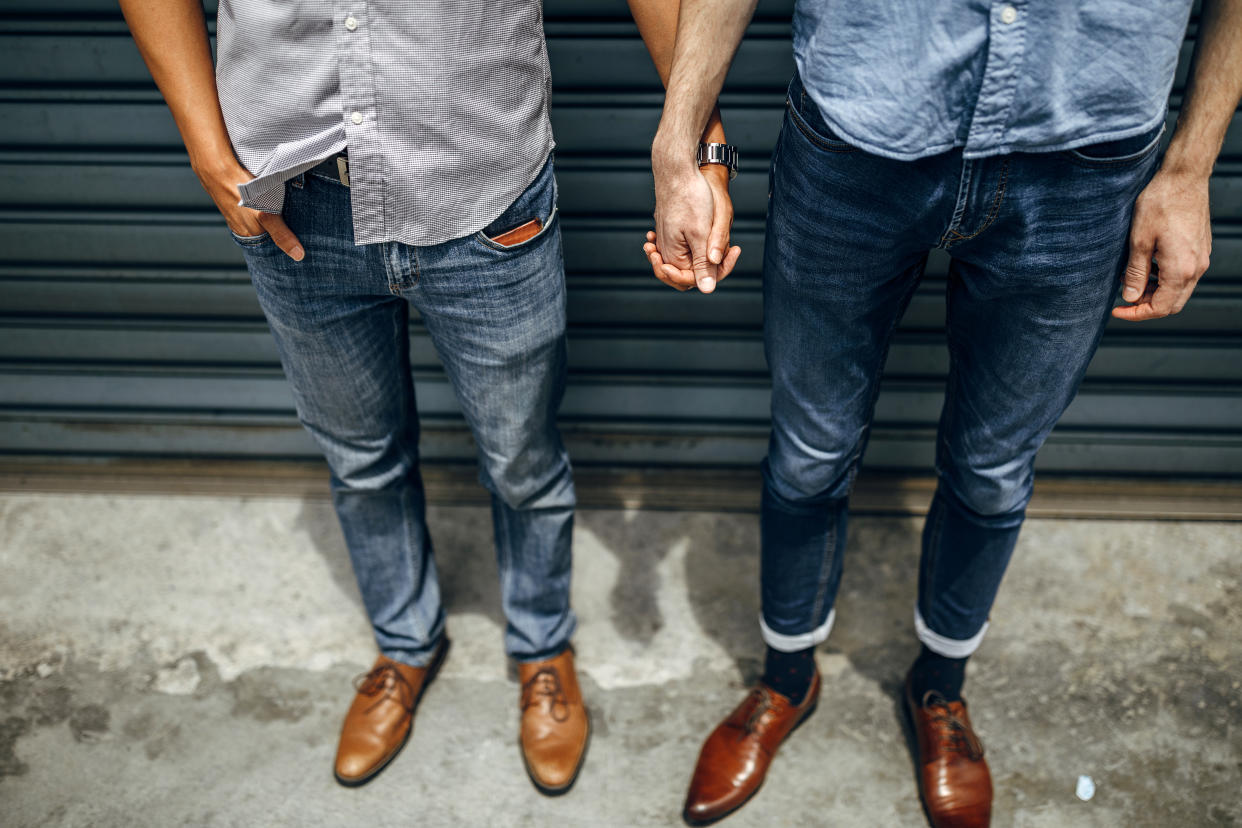 Homosexual couple holding hands outdoors in the city