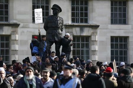 A Muslim demonstrator holds a placard during a protest against the publication of cartoons depicting the Prophet Mohammad in French satirical weekly Charlie Hebdo, near Downing Street in central London February 8, 2015. REUTERS/Stefan Wermuth