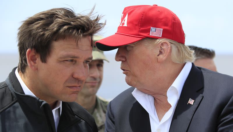 President Donald Trump talks to Florida Gov. Ron DeSantis, left, during a visit to Lake Okeechobee and Herbert Hoover Dike at Canal Point, Fla., March 29, 2019.