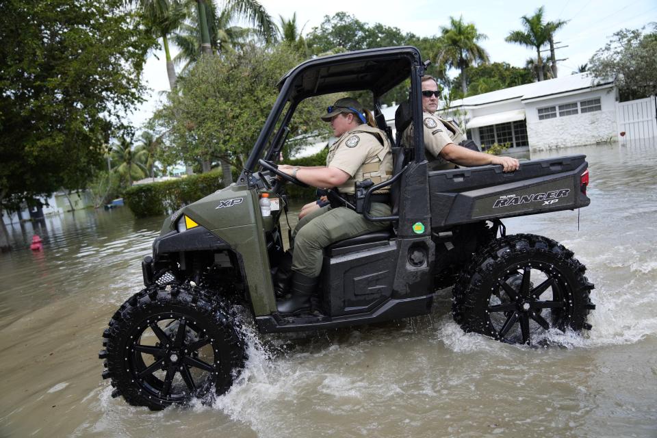 FILE - Officers from Florida's Fish and Wildlife Conservation Commission operate a response vehicle in receding floodwaters in the Edgewood neighborhood of Fort Lauderdale, Fla., April 13, 2023. Over 25 inches of rain fell in South Florida since Monday, causing widespread flooding. (AP Photo/Rebecca Blackwell, File)