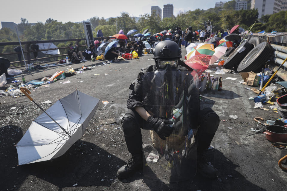 A pro-democracy protester with protection gears holds a bottle of molotov cocktail on a bridge outside the Chinese University campus in Hong Kong, Wednesday, Nov. 13, 2019. Police increased security around Hong Kong and its university campuses as they brace for more violence after sharp clashes overnight with anti-government protesters. (AP Photo/Ng Han Guan)