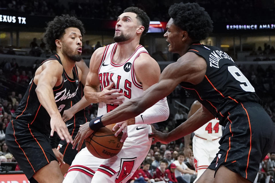 Chicago Bulls center Nikola Vucevic, center, drives to the basket as Detroit Pistons guard Cade Cunningham, left, and forward Ausar Thompson guard during the first half of an NBA basketball game in Chicago, Sunday, Nov. 12, 2023. (AP Photo/Nam Y. Huh)