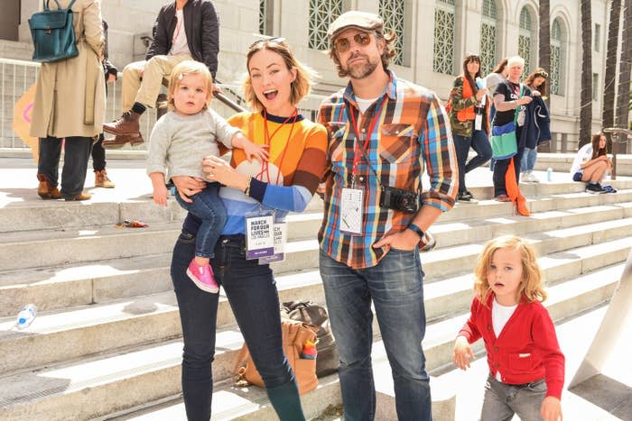 Jason and Olivia pose with their two children on a set of steps