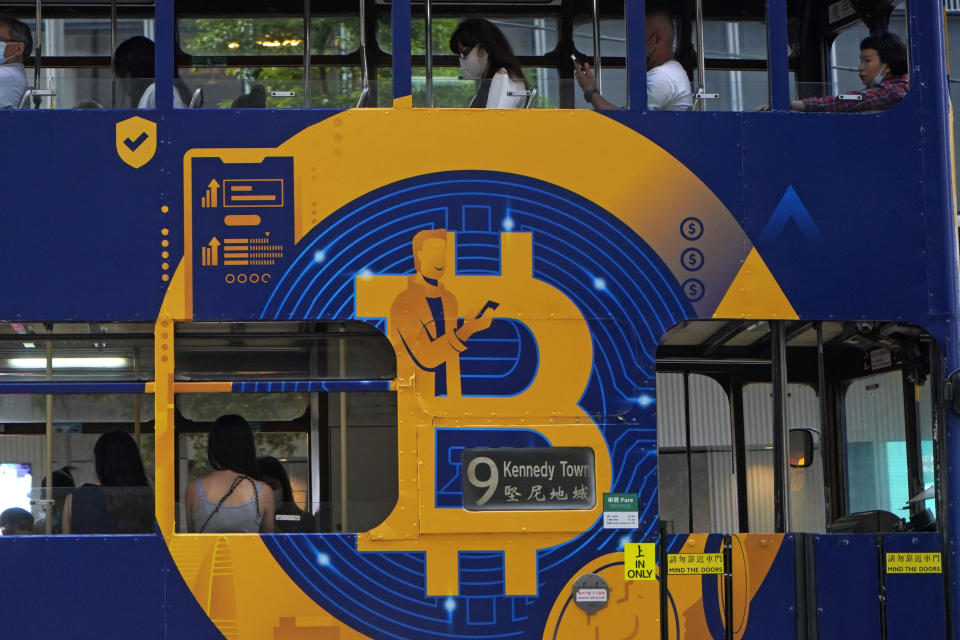 FILE - This May 12, 2021, file photo shows an advertisement for the cryptocurrency Bitcoin displayed on a tram in Hong Kong. Bitcoin is one of several cryptocurrencies that radical right provocateurs, banned by traditional financial institutions, are using to raise significant amounts of money and move it around the world. (AP Photo/Kin Cheung, File)