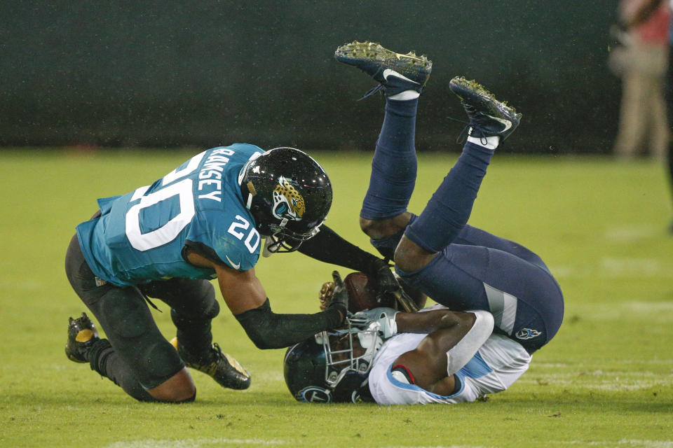 Jacksonville Jaguars cornerback Jalen Ramsey (20) tries to strip the ball from the hands of Tennessee Titans wide receiver A.J. Brown, right, after a reception during the first half of an NFL football game, Thursday, Sept. 19, 2019, in Jacksonville, Fla. (AP Photo/Stephen B. Morton)