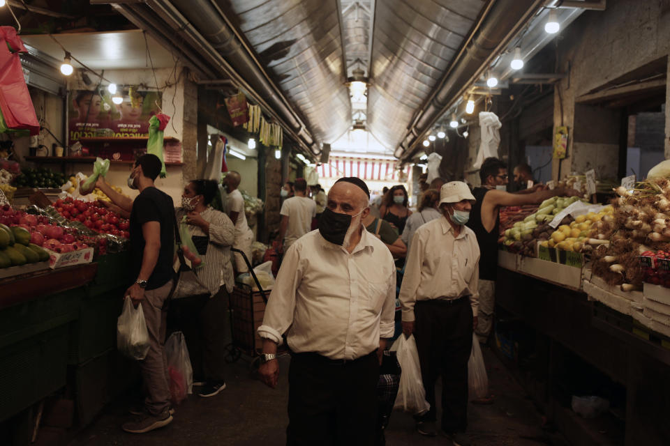 People shop in Machane Yehuda market in Jerusalem, Friday, Sept. 18, 2020, hours ahead of a nationwide three-week lockdown to curb the spread of the coronavirus. (AP Photo/Maya Alleruzzo)