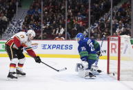 Calgary Flames' Milan Lucic, left, scores against Vancouver Canucks goalie Jacob Markstrom, of Sweden, during the third period of an NHL hockey game Saturday, Feb. 8, 2020, in Vancouver, British Columbia. (Darryl Dyck/The Canadian Press via AP)