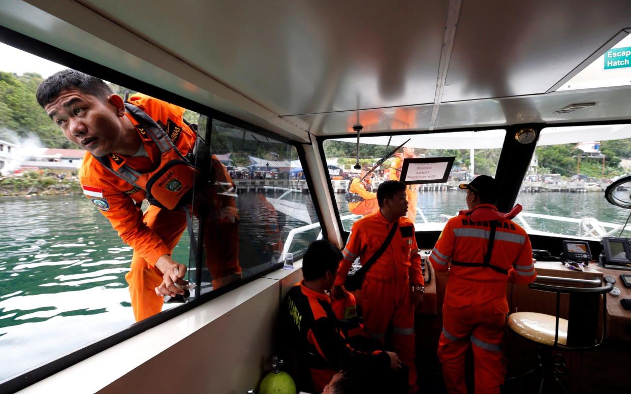 Rescue team members as seen inside a boat to find missing passengers from a ferry accident on Lake Toba - REUTERS