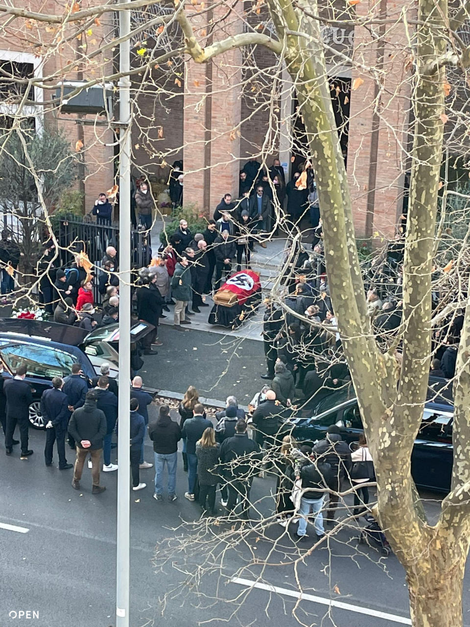 A picture made available by the Italian online news portal Open, showing people gathered around a swastika-covered casket outside the St. Lucia church, in Rome, Monday, Jan. 10, 2022. The Catholic Church in Rome on Tuesday, Jan. 11, 2022, strongly condemned as "offensive and unacceptable" a funeral procession outside a church in which the casket was draped in a Nazi flag and mourners gave the fascist salute. (Open Via AP)